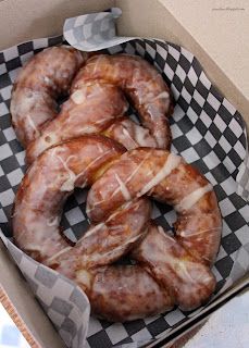 a box filled with donuts covered in icing on top of checkered paper