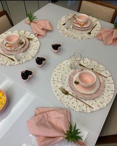 the table is set with pink and white dishes