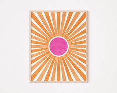 an orange and pink sunburst on a white wall