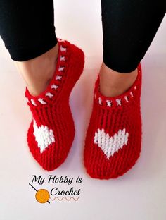 a pair of red knitted shoes with white hearts