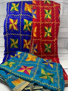 three pieces of cloth with different colors and designs on the top one is blue, red, yellow and green