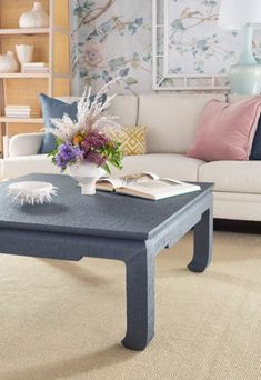 a living room filled with furniture and a coffee table in front of a book shelf