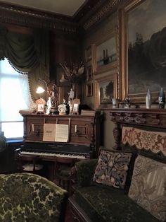 a living room filled with furniture next to a painting on the wall above a piano