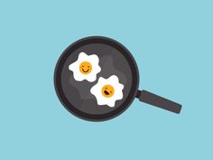 two fried eggs in a frying pan with smiley faces