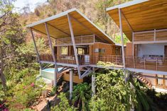 the house is surrounded by greenery and has three levels that are connected to each other