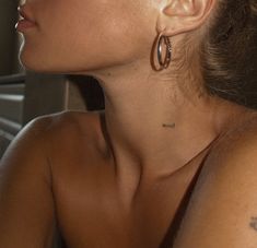 a woman with large hoop earrings on her neck looking off to the side, in profile