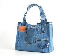 a denim bag with an orange tag hanging from it's front pocket, on a white background