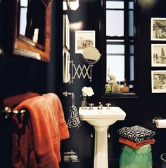 a white sink sitting under a bathroom mirror next to a green pot filled with flowers