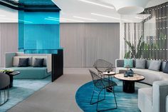 a living room filled with lots of furniture and walls covered in blue stripes on the ceiling