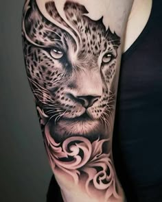 a woman's arm with a black and white tattoo on it, featuring a cheetah