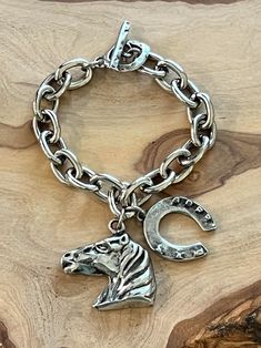 This western or cowboy themed chain bracelet was handmade with all quality materials and is approximately 7" in size.  The silver chain is antiqued pewter over steel.  The horse and horsehoe charms are antiqued pewter. The bracelet was finished with a beautiful antiqued silver over pewter toggle.  You will love the quality of this bracelet!  Get this for yourself or to give as a birthday or anniversary gift. * Each of our jewelry items come in a drawstring jewelry pouch ready for gift giving or for storing.  * Note-Different lighting and monitors can vary on hue intensity and shading. Bracelet For Boys, Drawstring Jewelry Pouch, Western Bracelets, Cow Boys, Mens Chain, Mens Chain Bracelet, Antique Pewter, Cow Boy, Handmade Bracelet