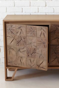 a sideboard made out of wooden blocks with handprinted designs on the doors