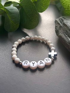 - Sweet baby boy cross bracelet with white howlite gemstone. A perfect baptism or first holy communion bracelet. Personalized boy  for easy gifting. Beaded on high quality stretch cord and secured. - 4mm platinum plated accent beads   4.5mm white howlite   platinum plated cross   acrylic letter beads ‼️Young children MUST be supervised at all times while wearing jewelry. Contains small parts that could be a potential choking hazard. Jewelry should always be removed during sleep. Never leave youn Bracelet Boy, Baptism Bracelet, Toddler & Baby Boy Style, Godson Gifts, Newborn Baby Boy Outfit, Christian Bracelets, Wearing Jewelry, Boy Christening, Baptism Party