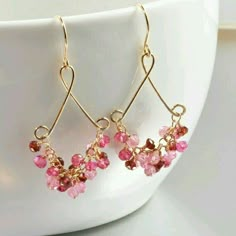 pink and gold earrings on a white cup