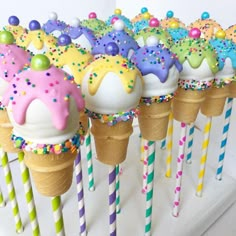 there are many ice cream cones with sprinkles on them and candy sticks