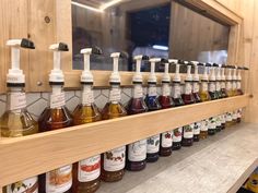 bottles of different kinds of liquid are lined up on a shelf