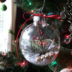 an ornament hanging from a christmas tree decorated with ornaments and lights, in front of a window