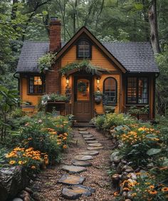 a small house in the woods with lots of plants and flowers on the front yard