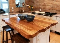 a kitchen island with two bowls on it in front of an oven and counter top