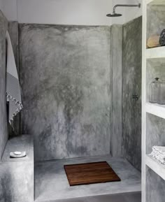 a walk in shower sitting next to a shelf filled with bottles