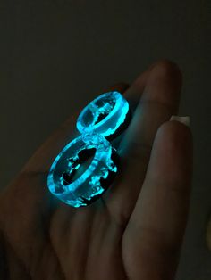 a person is holding two rings in their hand with glowing lights on them and the ring has an oval shape