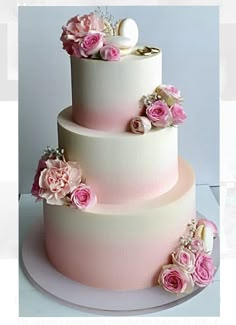 a three tiered wedding cake with pink and white flowers