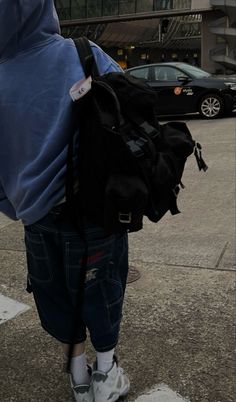 a person with a backpack on their back walking down the street