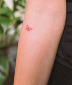 a woman's arm with a butterfly tattoo on the left side of her arm