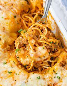 a casserole dish with meat, cheese and noodles in it is being eaten by a fork