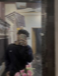 a blurry image of a man in a black jacket walking down the street while talking on his cell phone