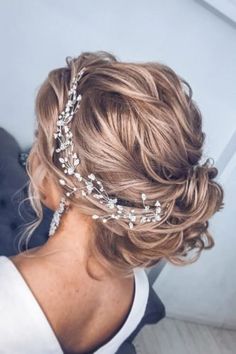 a woman with blonde hair wearing a headpiece made of pearls and crystals in her hair