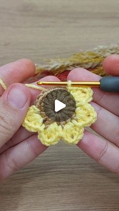 someone is crocheting a flower on a piece of yarn