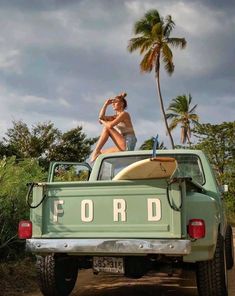 a woman sitting on the back of a pick up truck