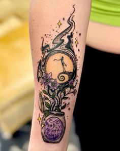 a woman's arm with a clock and flowers tattoo on the left side of her arm