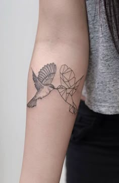 a woman's arm with a tattoo on it and a bird in the middle