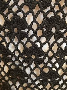 an image of black crocheted material with white dots on it's surface