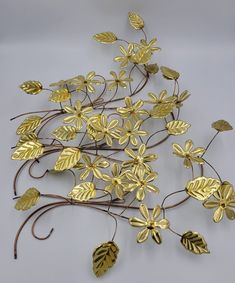 a group of metal flowers and leaves on a white surface