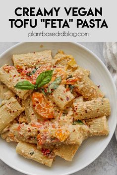 creamy vegan tofu feta'pasta on a white plate with basil leaves