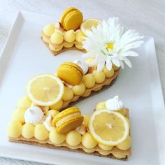 a white plate topped with slices of lemon and other food next to a flower on top of it