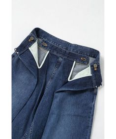 a pair of blue jeans with buttons on the back and side pockets, sitting against a white background