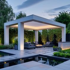 an outdoor living area is lit up with lights and water features in the foreground