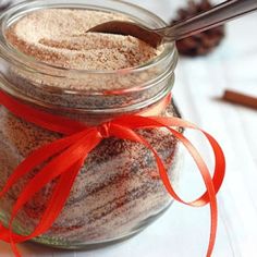 a jar filled with cinnamon sugar and topped with a red ribbon