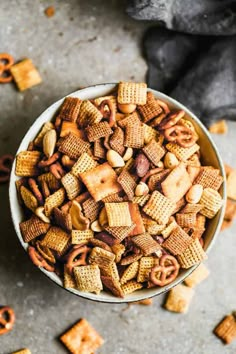 a bowl filled with cheetos and pretzels on top of a table