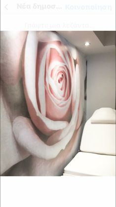 an image of a pink rose on the wall in a room with white furniture and lighting