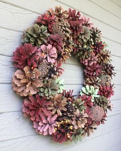 a wreath made out of pine cones is hanging on the wall