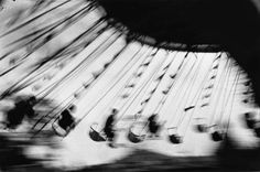 black and white photograph of an old fashioned carnival ride with lots of strings hanging from the ceiling