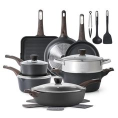 an assortment of pots and pans with spatulas next to them on a white background