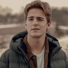 a young man in a parka looking at the camera