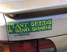 there is a plant seeds and sing songs sticker on the back of a car