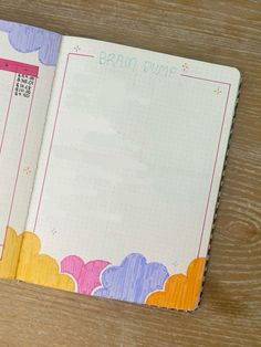 an open planner book sitting on top of a wooden table